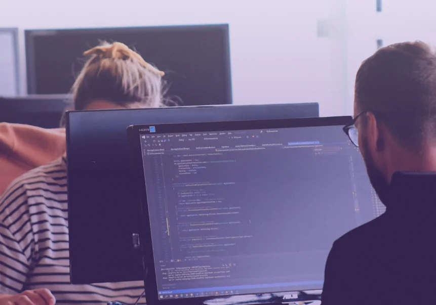 Equipe trabalhando em uma tela de código e integração de software